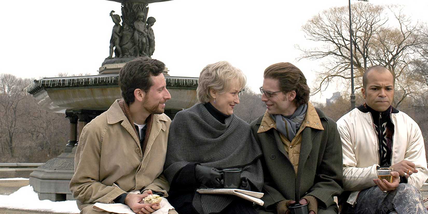 O elenco sentado em uma fonte em Angels in America