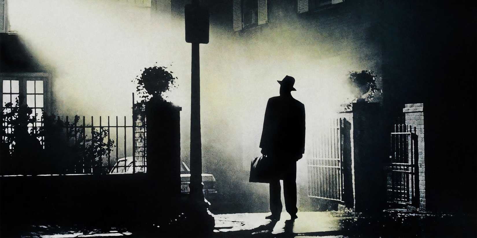 Father Karras stands in a shaft of light outside of the house in The Exorcist