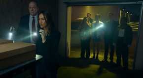 The group holding flashlights and investigating boxes in a storage unit in Ballard