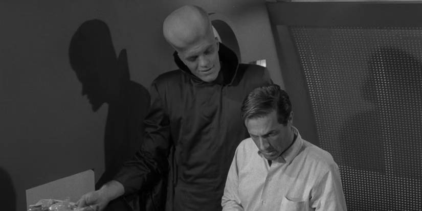Um alienígena imponente se inclina sobre Michael Chambers (Lloyd Bochner) em The Twilight Zone