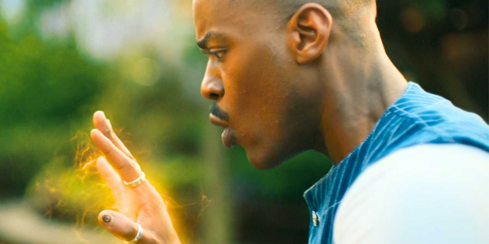 O décimo quinto médico de Ncuti Gatwa olhando para sua mão brilhante no jardim de Belinda, pouco antes de se regenerar, em Doctor Who.