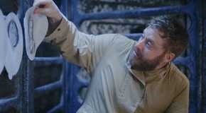 Alan Tudyk as Harry Vanderspeigle hanging up pictures in Resident Alien