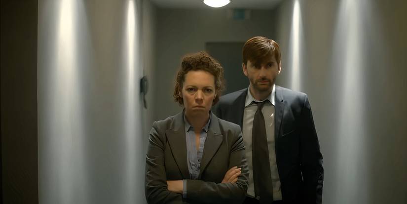 A devastated Ellie and Alec walking down a hall in the police station, on their way to see Joe in custody, in Broadchurch.