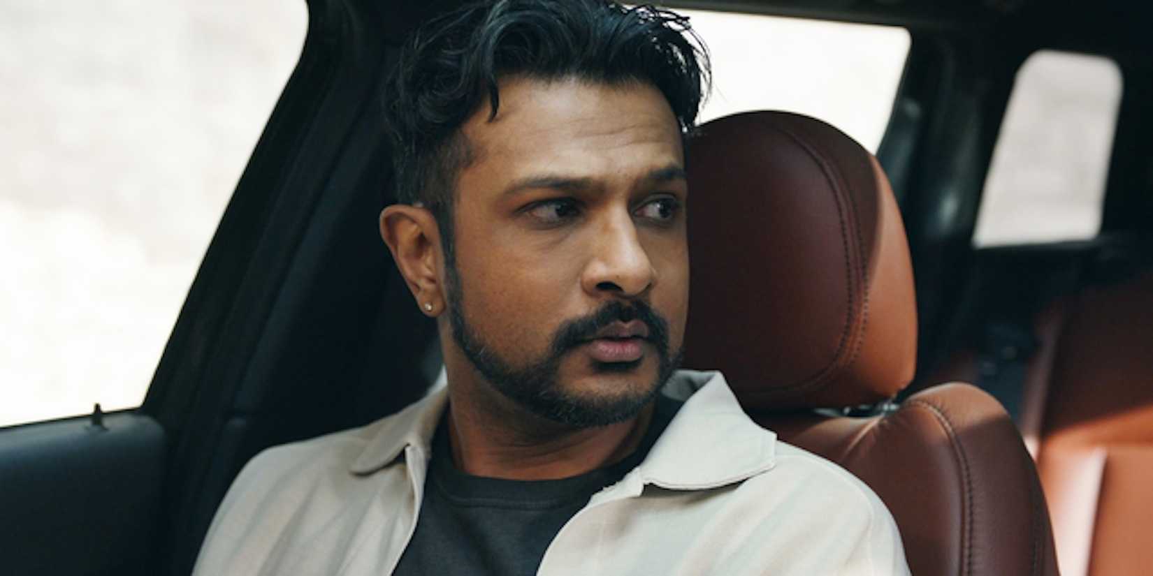 Jay Utkarsh Ambudkar duduk di mobil di Ghosts Season 4