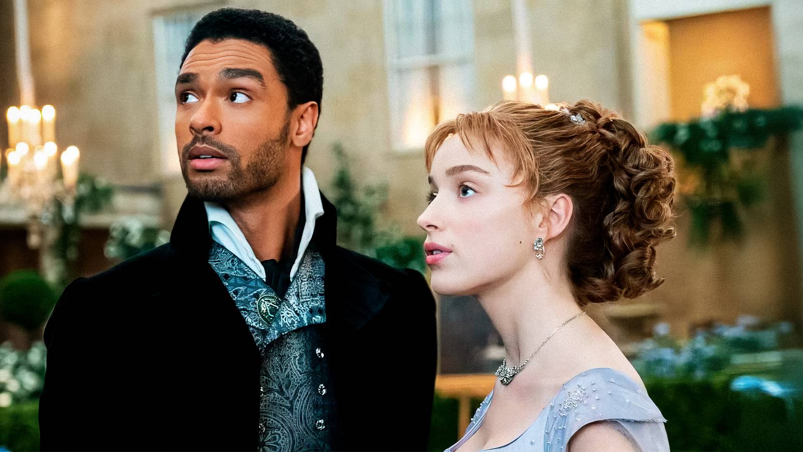 Rege Jean Pege and Phoebe Dynevor at a ball looking at something offscreen in Bridgerton