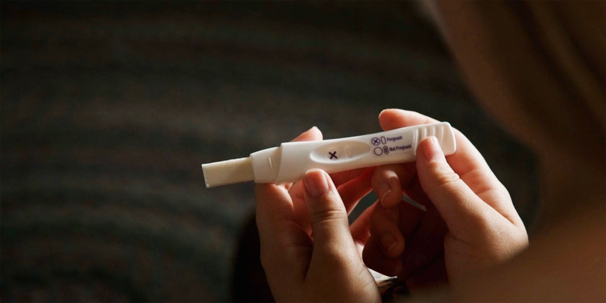 Young Beth looks at a positive pregnancy test in Yellowstone
