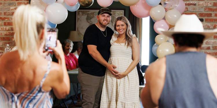 The McBee Dynasty: Real American Cowboys' Cole McBee and Kacie Adkison posing for a photo at their gender reveal