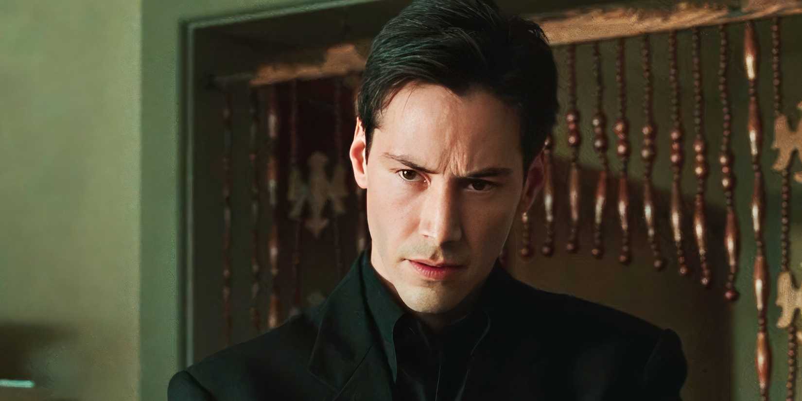 Neo looks down while talking to someone in The Matrix
