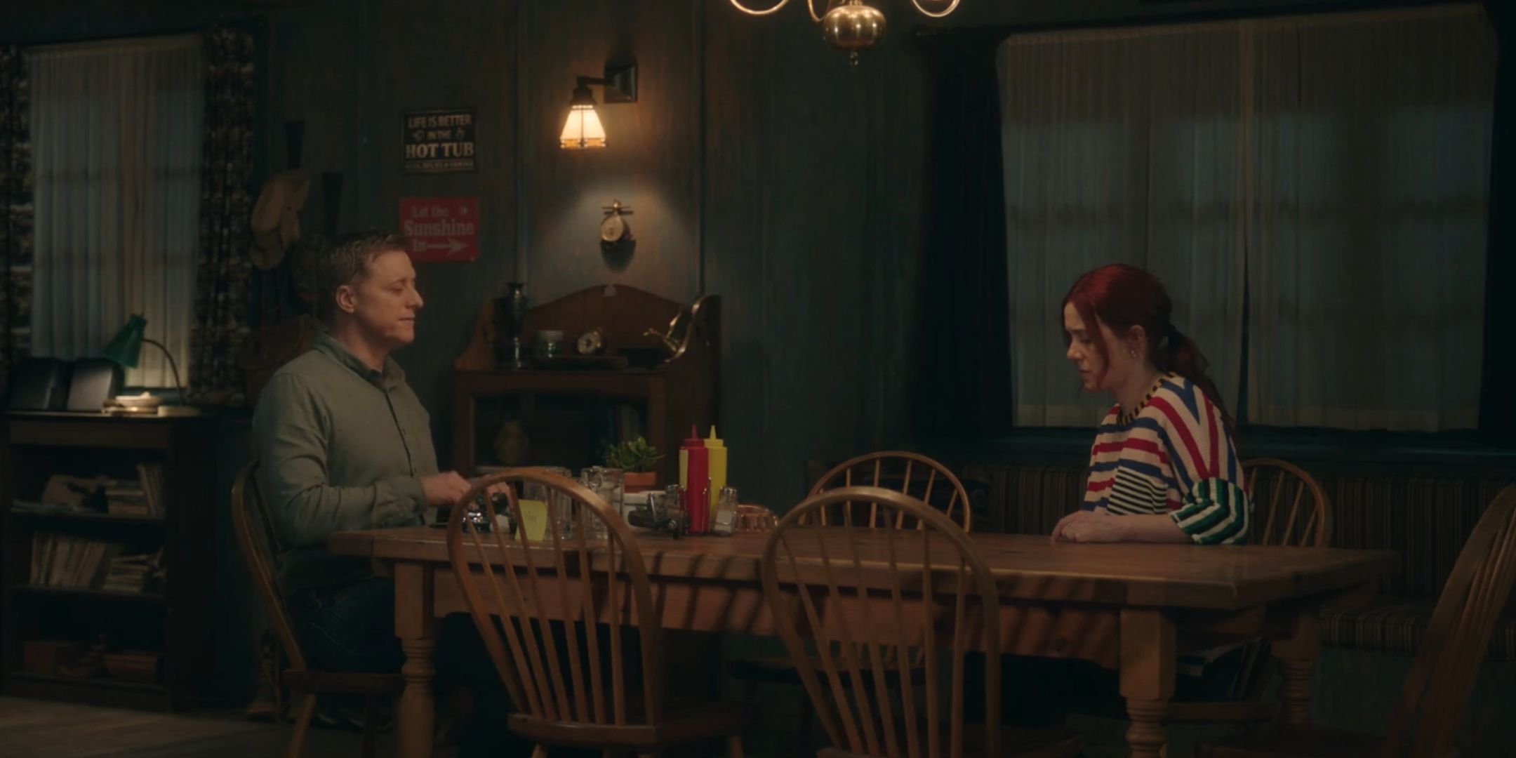 Harry and D'arcy sitting at a table together in Resident Alien