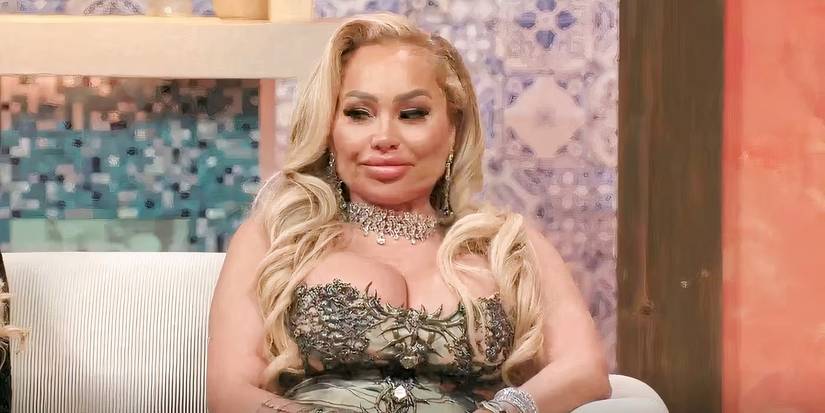 90 day fiance celeb darcey silva with a sparkly dress on sitting on a couch brightened