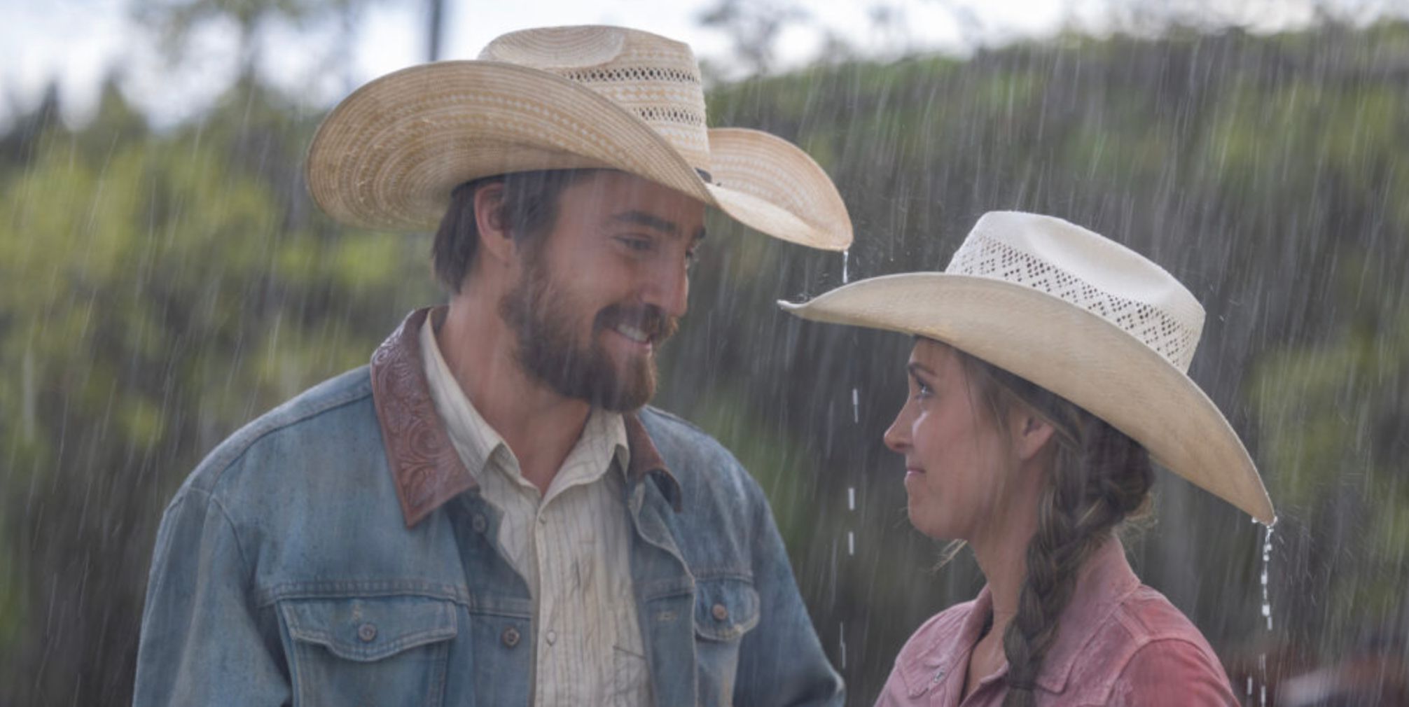 A man and woman smiling in the rain in Heartland