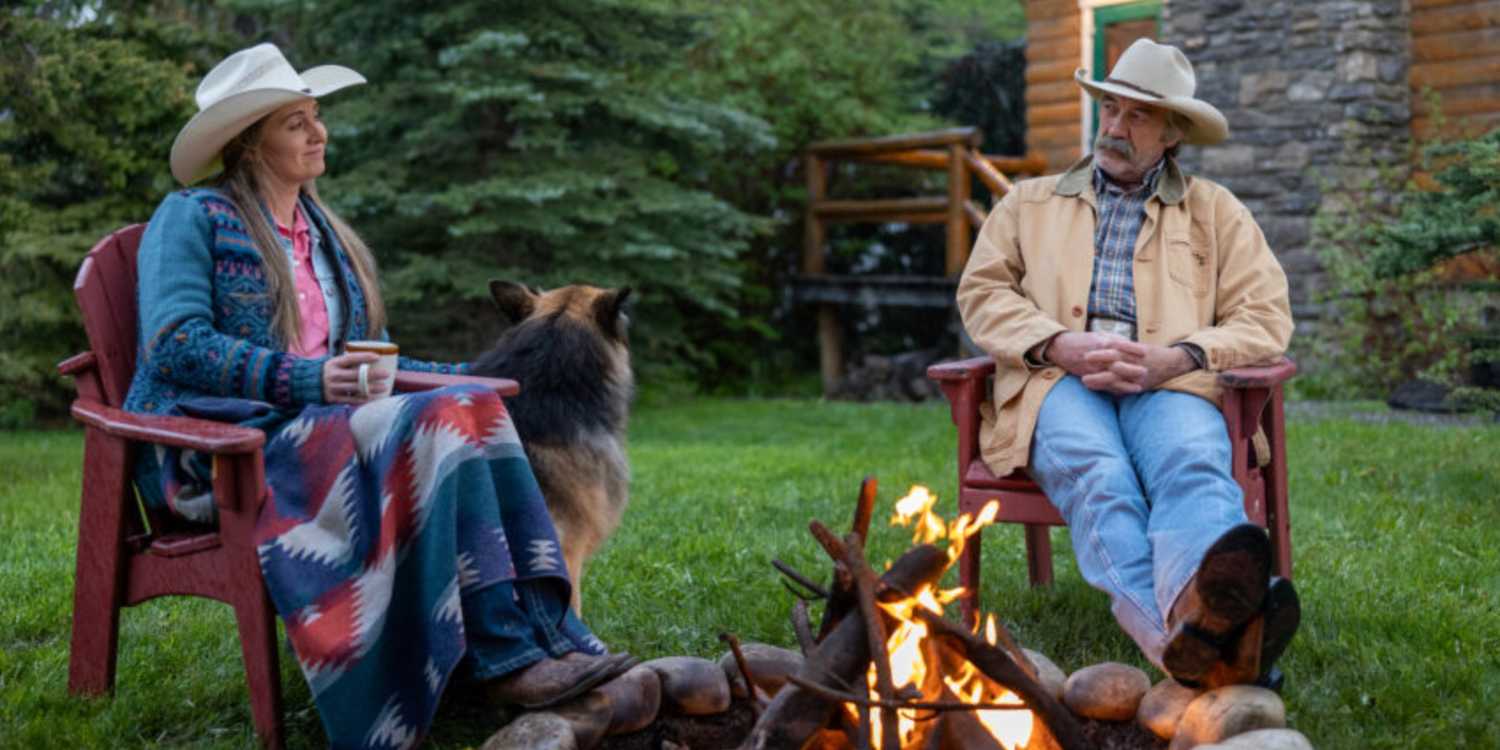 A woman sitting by an outdoor fire with a man and a dog in Heartland