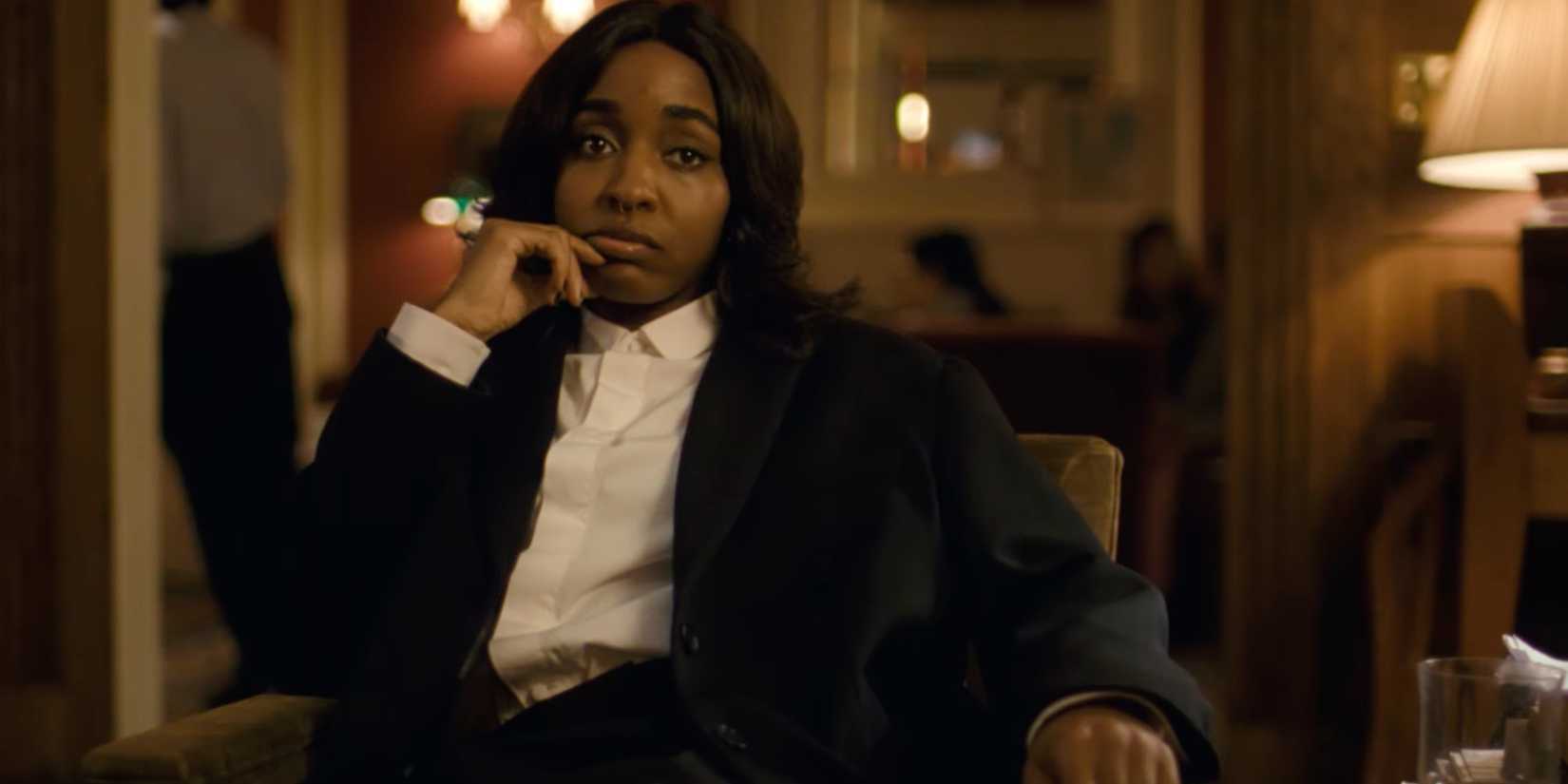 Ayo Edebiri looking bored while wearing a suit in After the Hunt