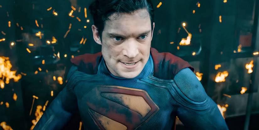 Battle-worn Superman from DCU's 2025 film standing with singed suit and fire bits around him