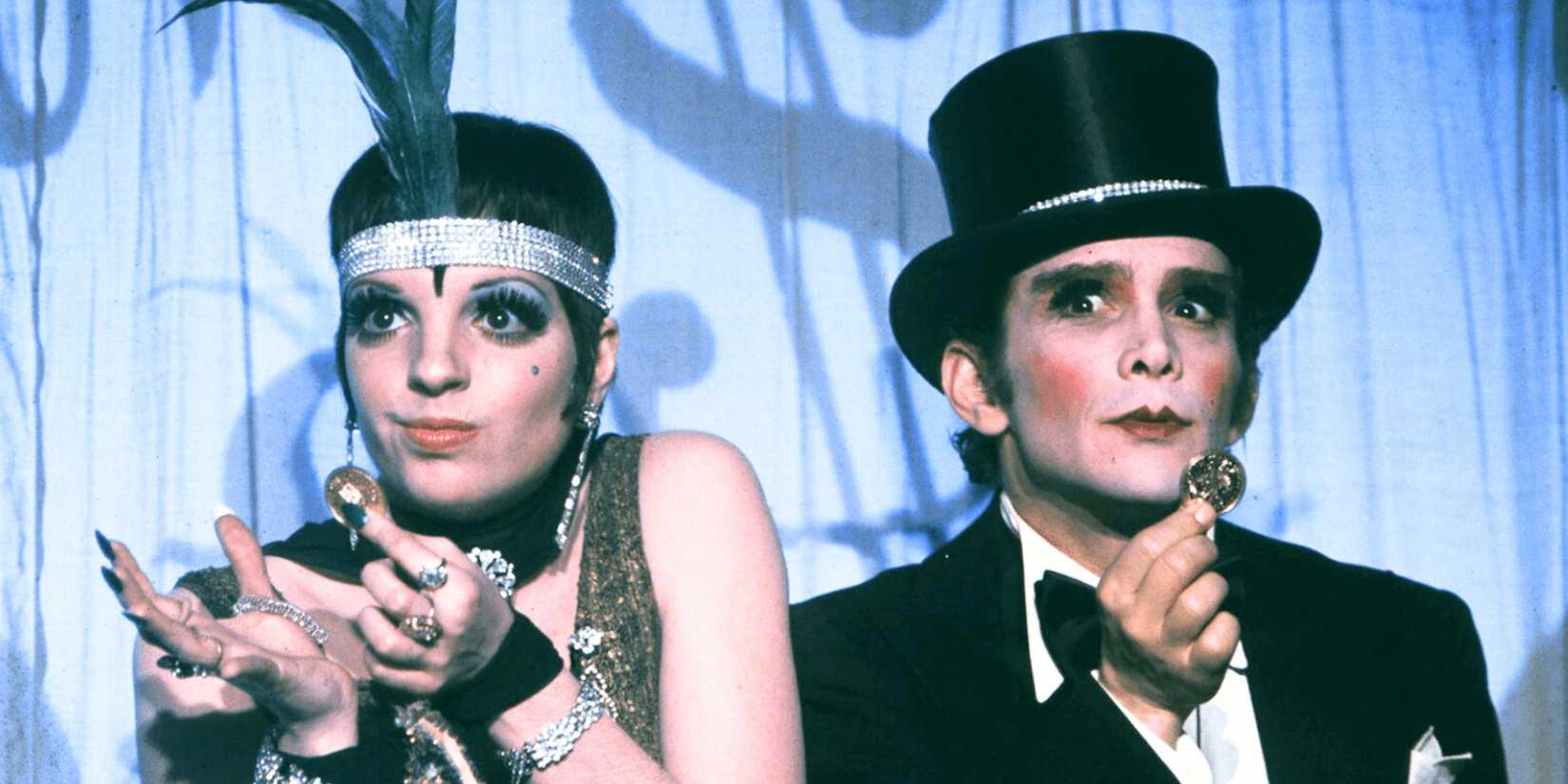 Sally and the Emcee hold up gold coins while performing on stage in Cabaret
