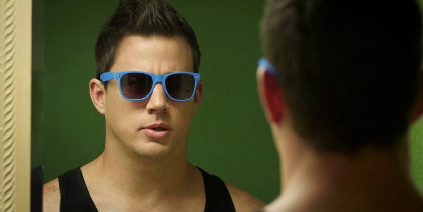 Channing Tatum looking in the mirror with blue sunglᴀsses on in 22 Jump Street