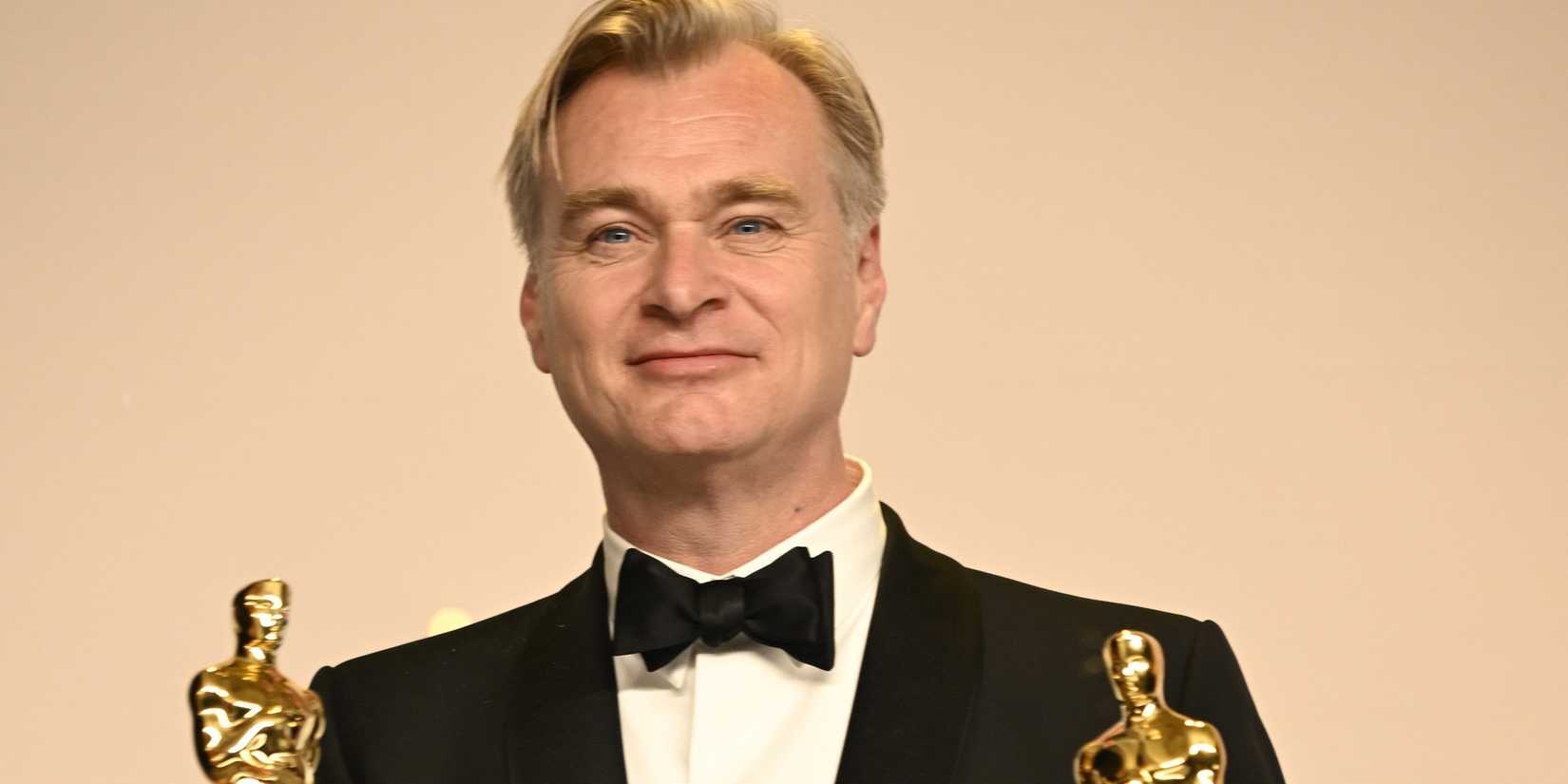 Christopher Nolan holding Oscars statues