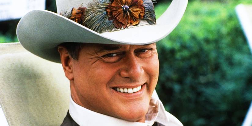JR Ewing sorrindo em uma cena de Dallas