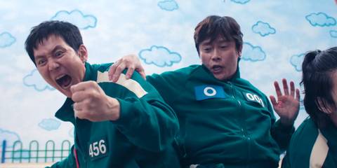 Gi-hun is excited while the Front Man holds him in Squid Game