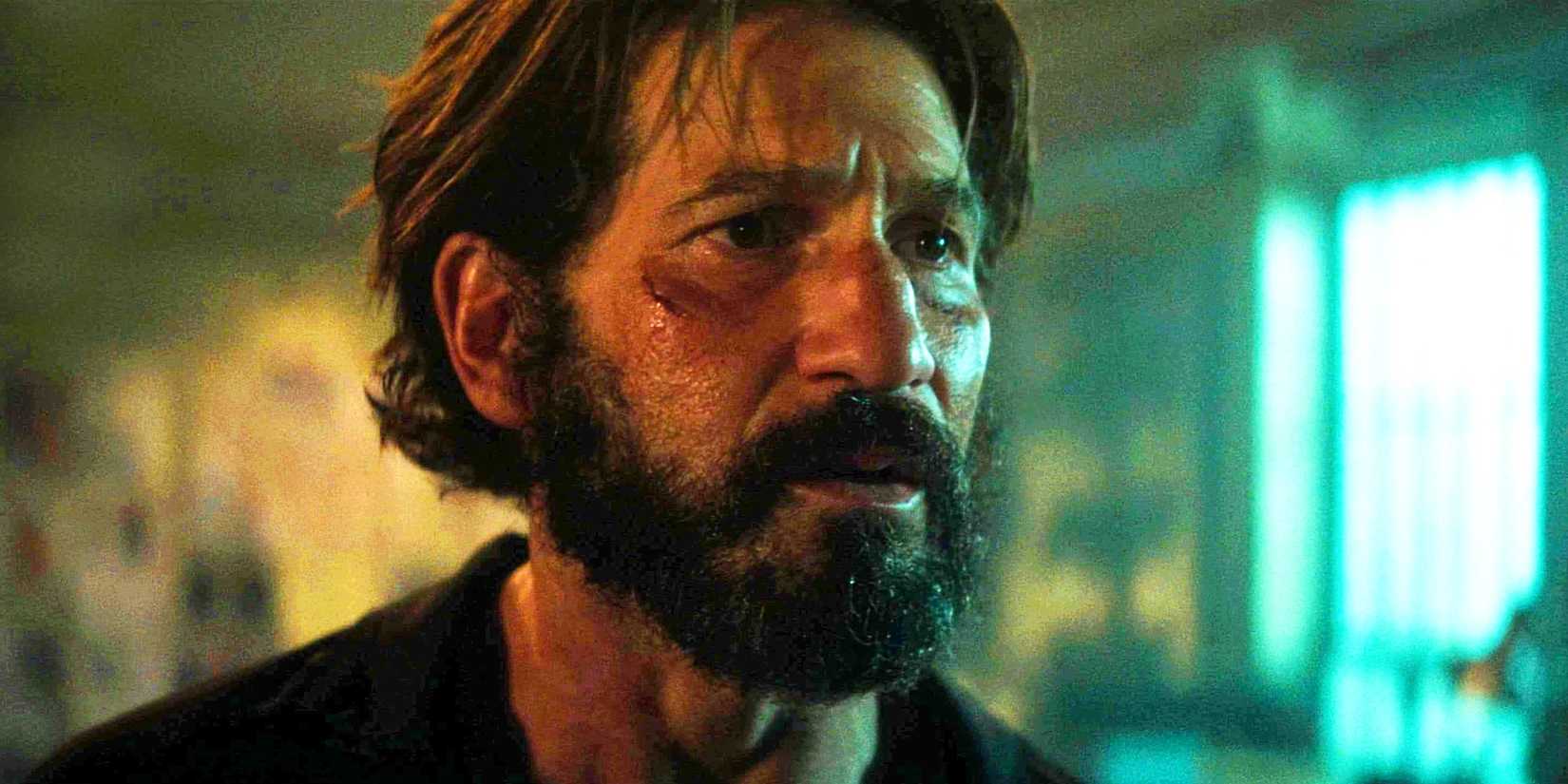 Jon Bernthal com barba e um pequeno corte no rosto, olhando seriamente para algo em Daredevil Born Again