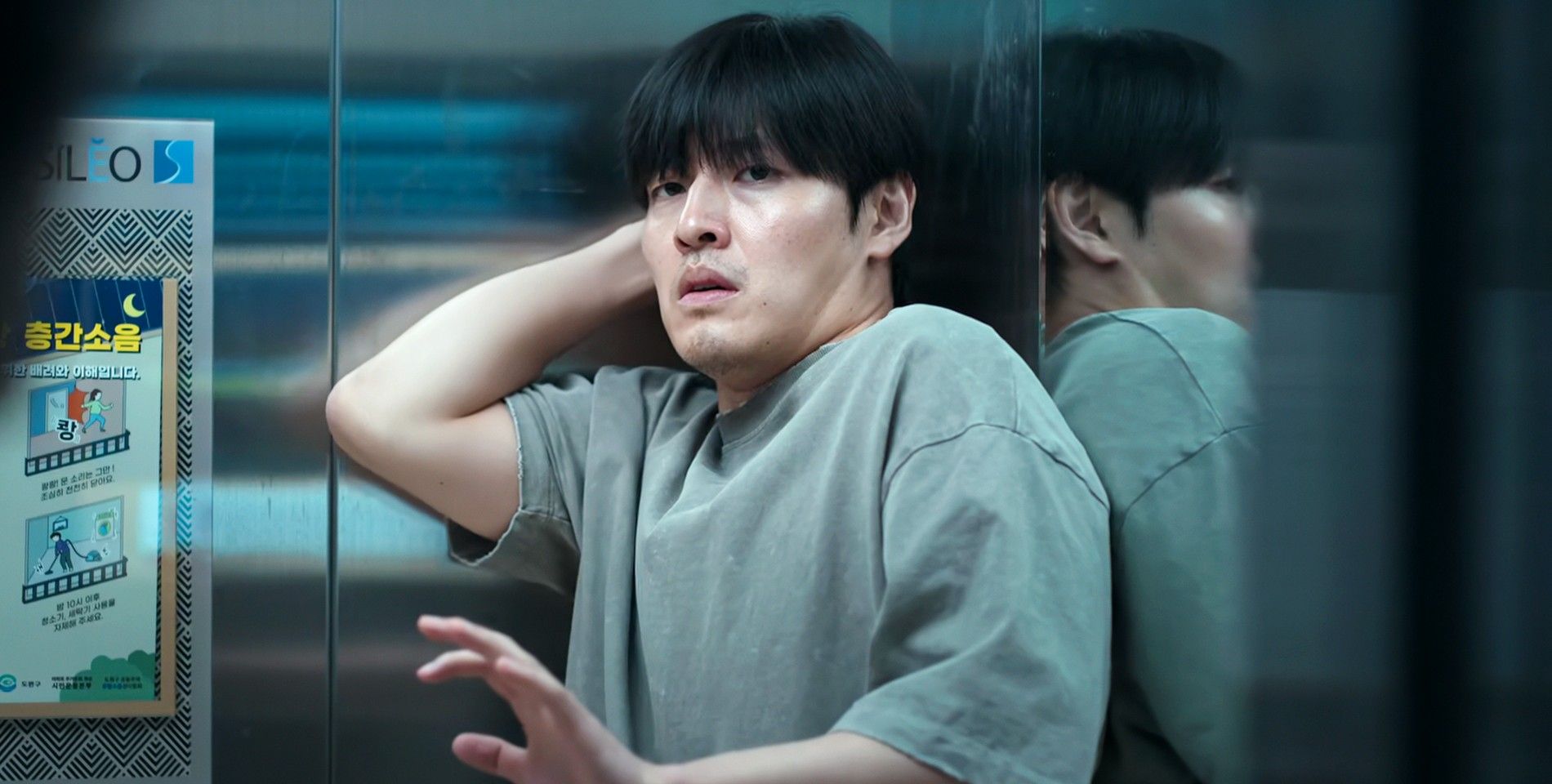 Kang Ha-neul is raising his hand up in the elevator in Wall to Wall