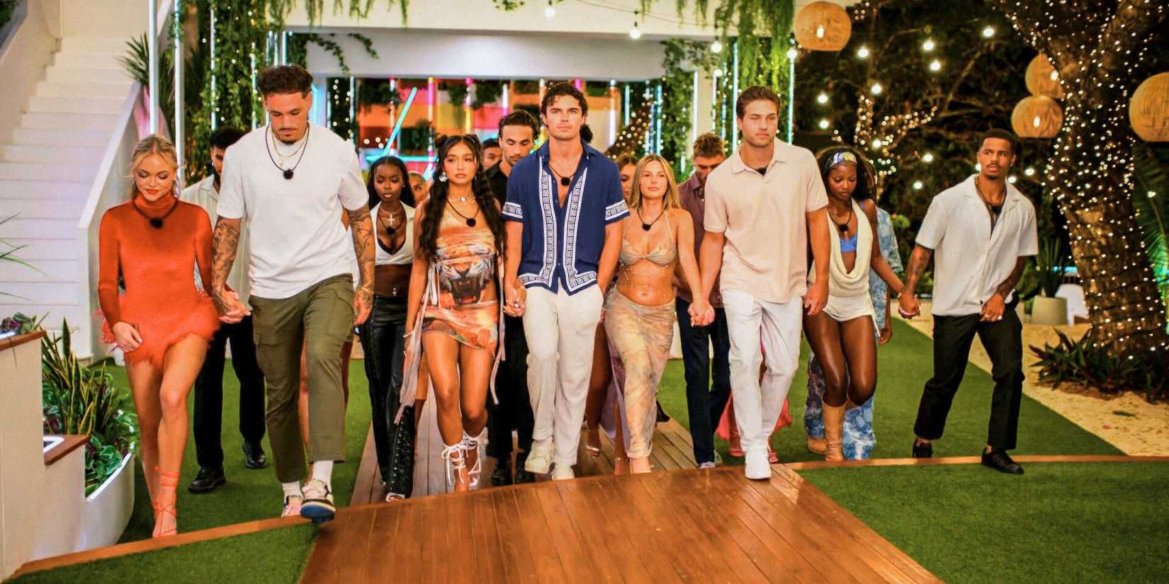 Пара участников Love Island USA 7 сезона, идущих, держась за руки