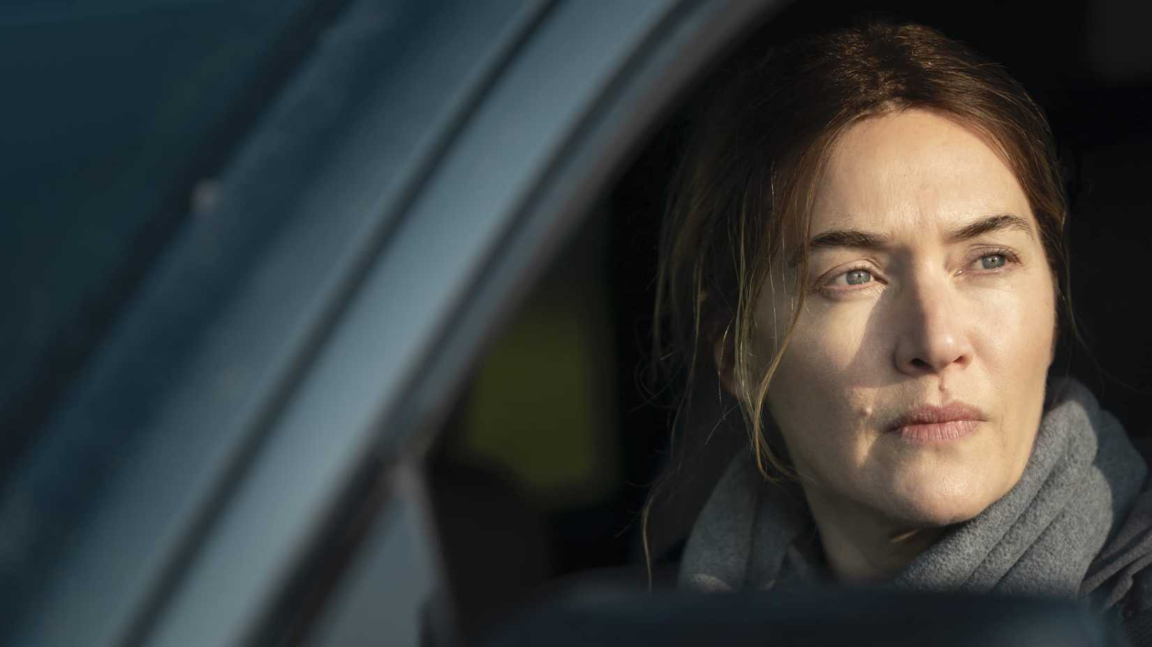 Mare (Kate Winslet) olhando pela janela do carro em Mare of Easttown.