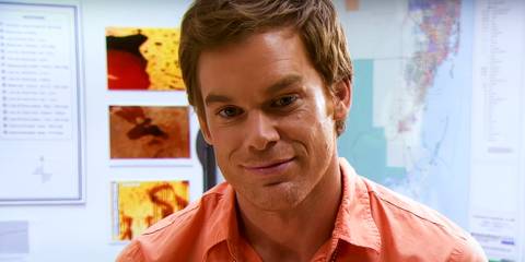 Michael C. Hall as Dexter Morgan smiling at Miami Metro in an orange shirt in Dexter