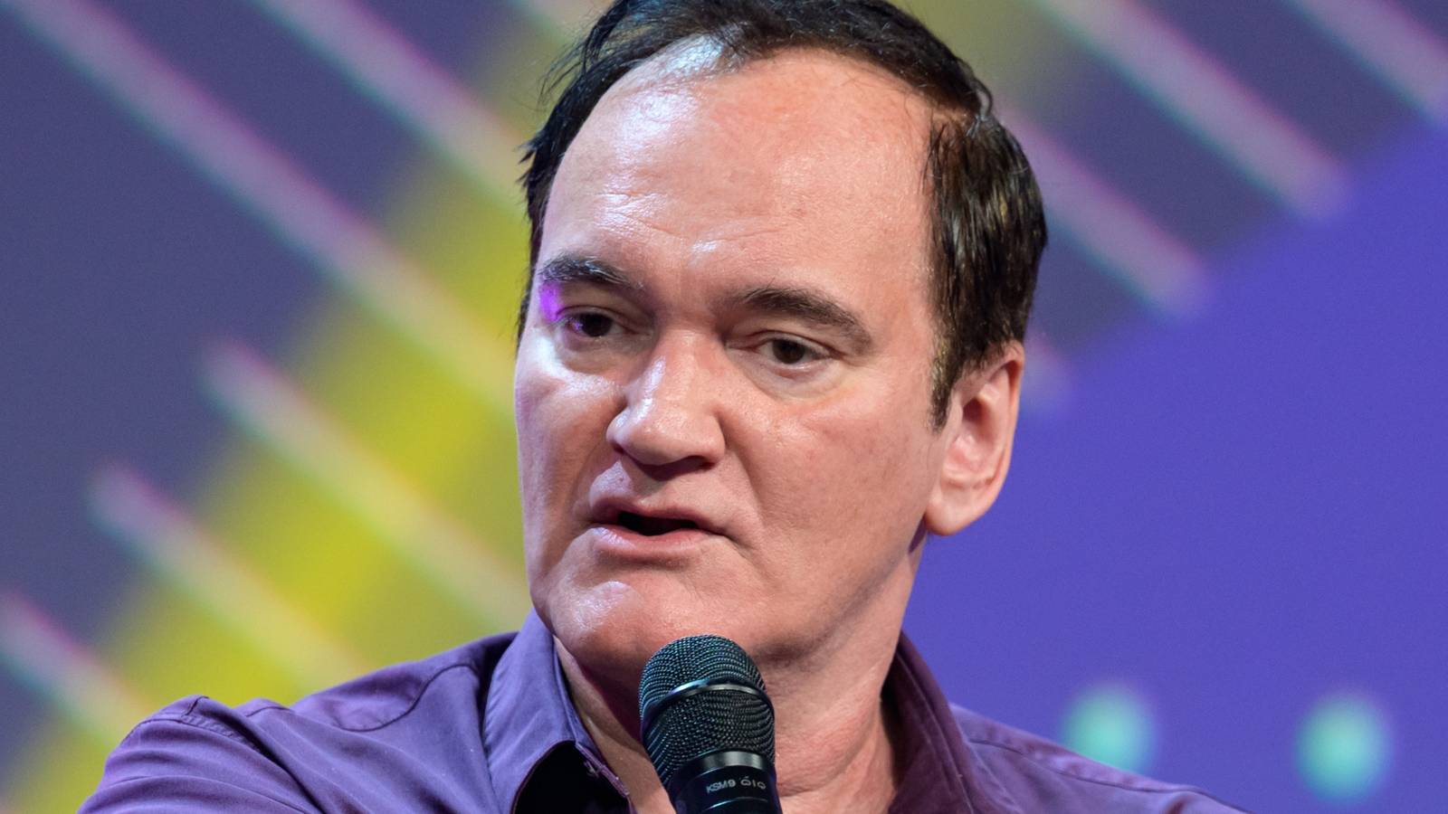 Quentin Tarantino holding a microphone