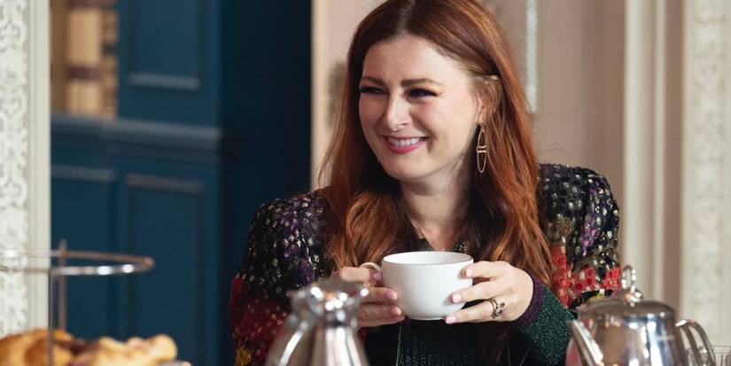 Rachel Reilly holding a teacup and laughing in the Traitors breakfast room.