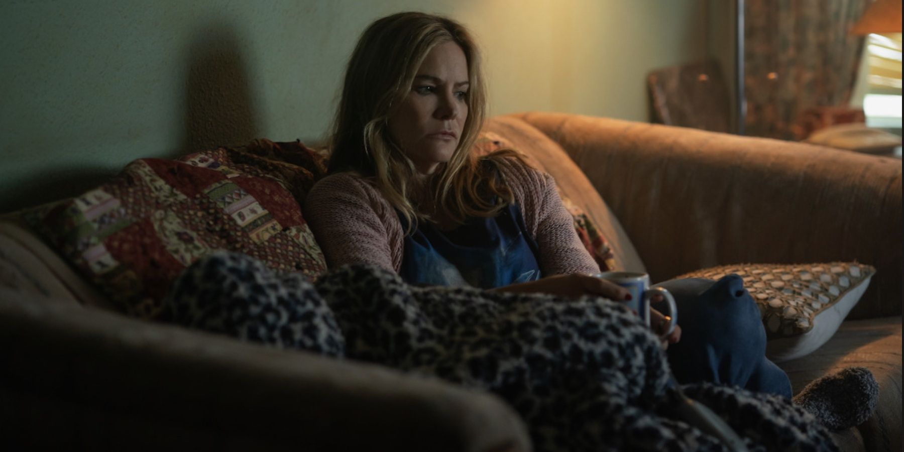 Jennifer Jason Leigh on a couch in Night Always Comes