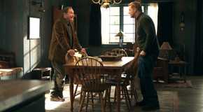 Stephen Root's Ed smiling and Alan Tudyk's Harry looking awkwardly while standing at dining table in Resident Alien season 4
