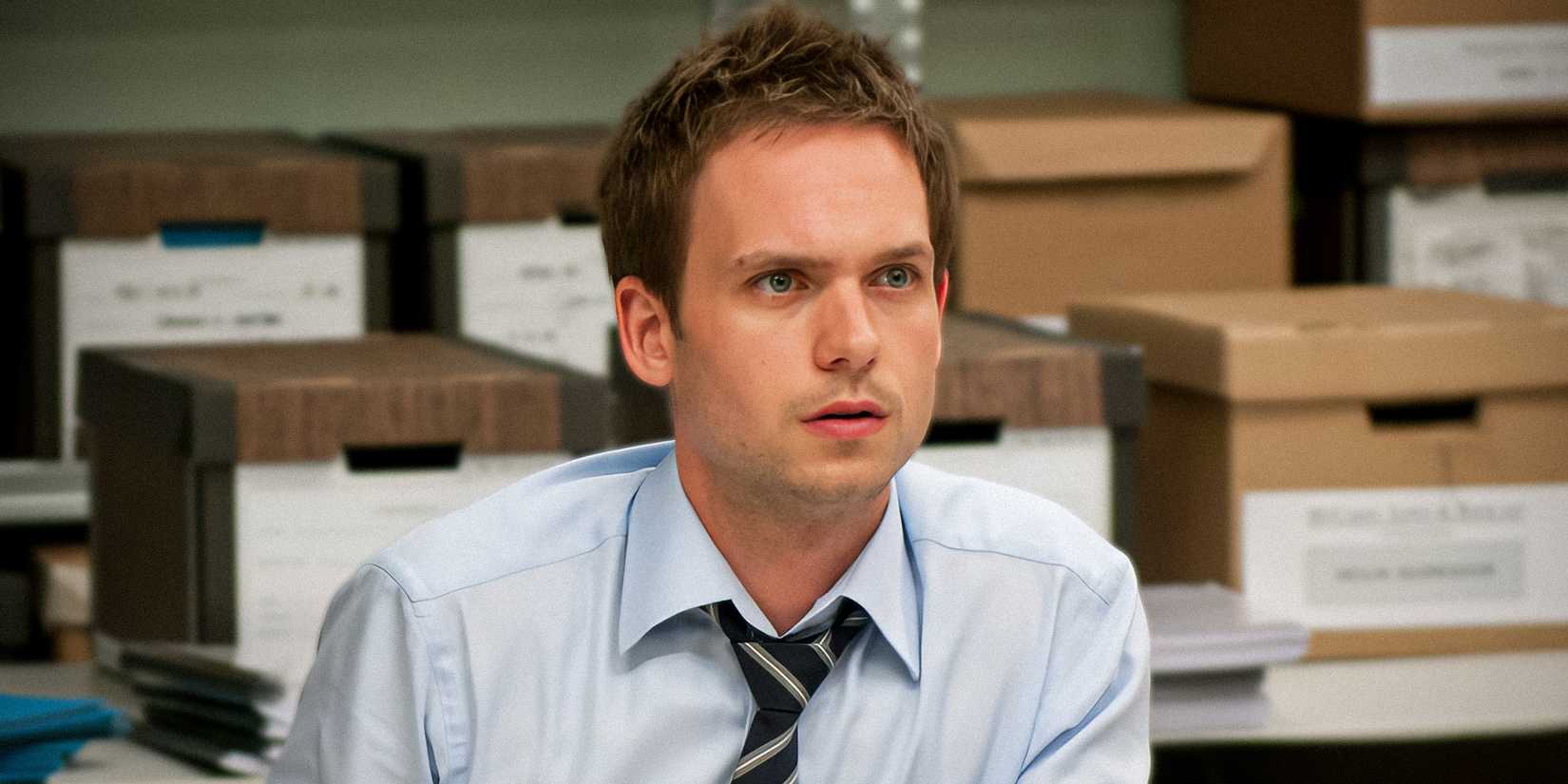 Patrick J. Adams as Mike in Suits looking sleep deprived while surrounded by case boxes