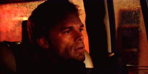 Dexter Morgan (Michael C. Hall) sitting in the back of a car in Dexter season 1, episode 1