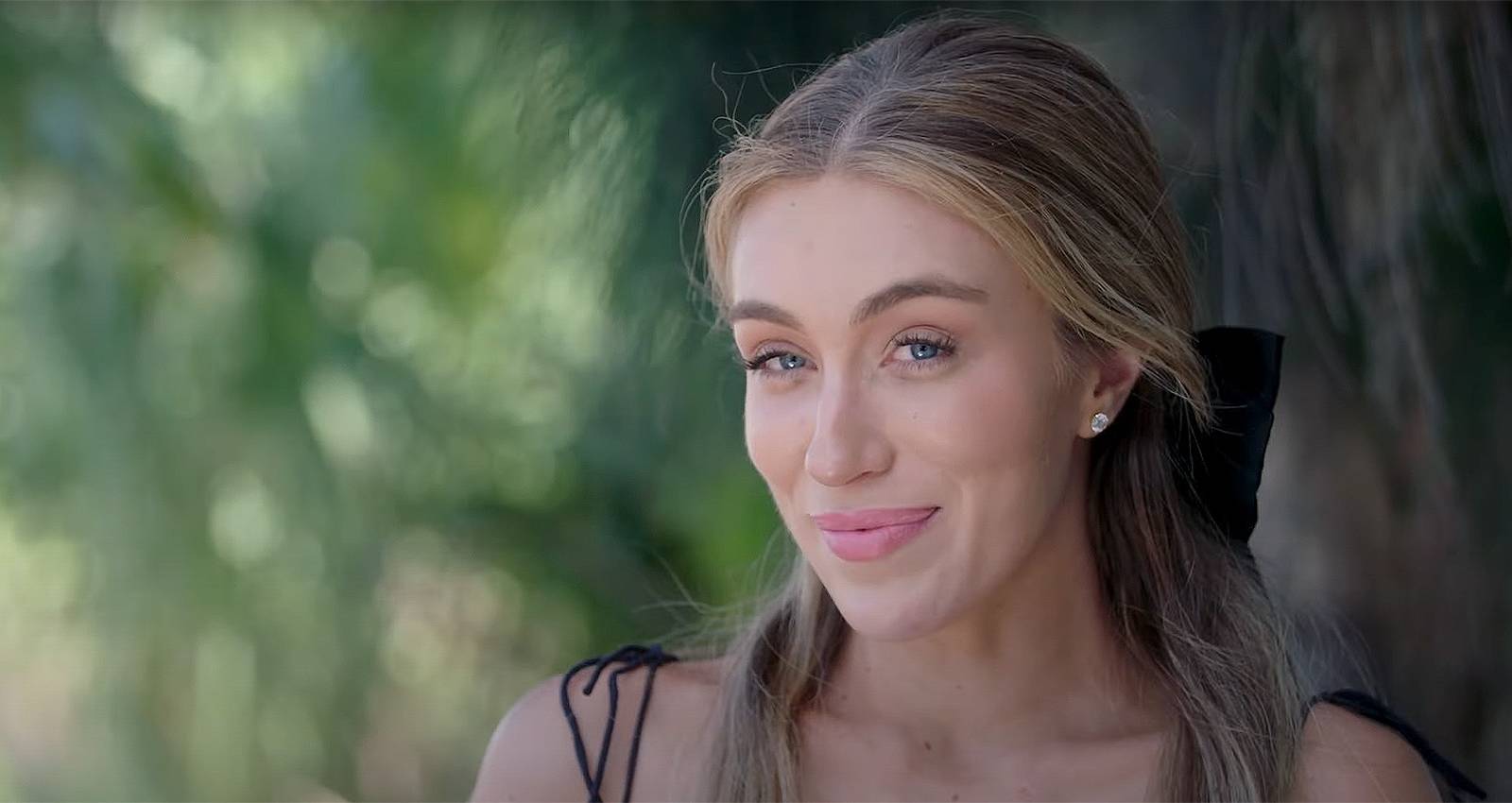 Veronica Peters from Welcome To Plathville smiling for the camera in a black dress.