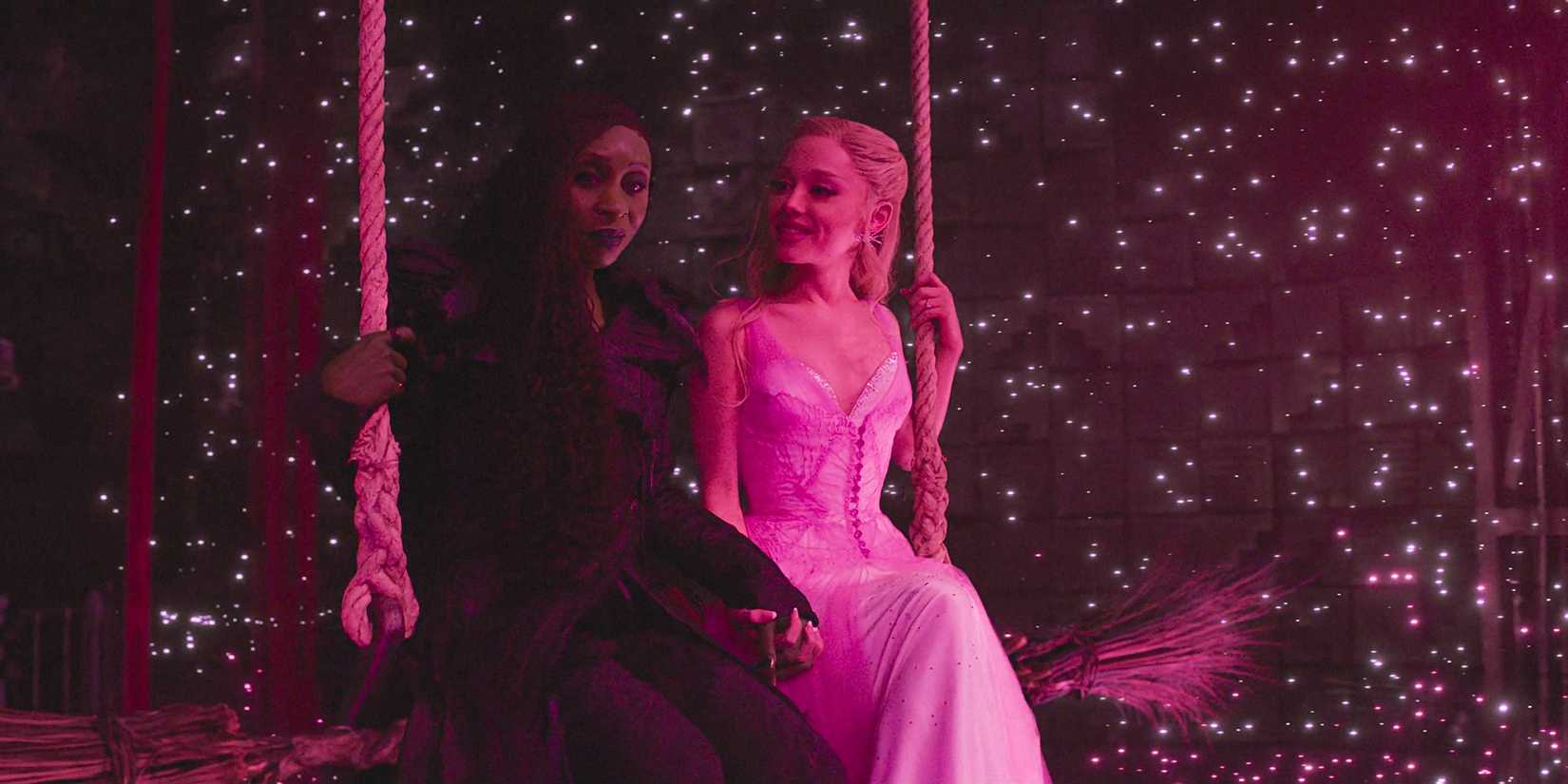 Elphaba e Glinda sedute su una altalena circondate da scintille in Wicked: For Good