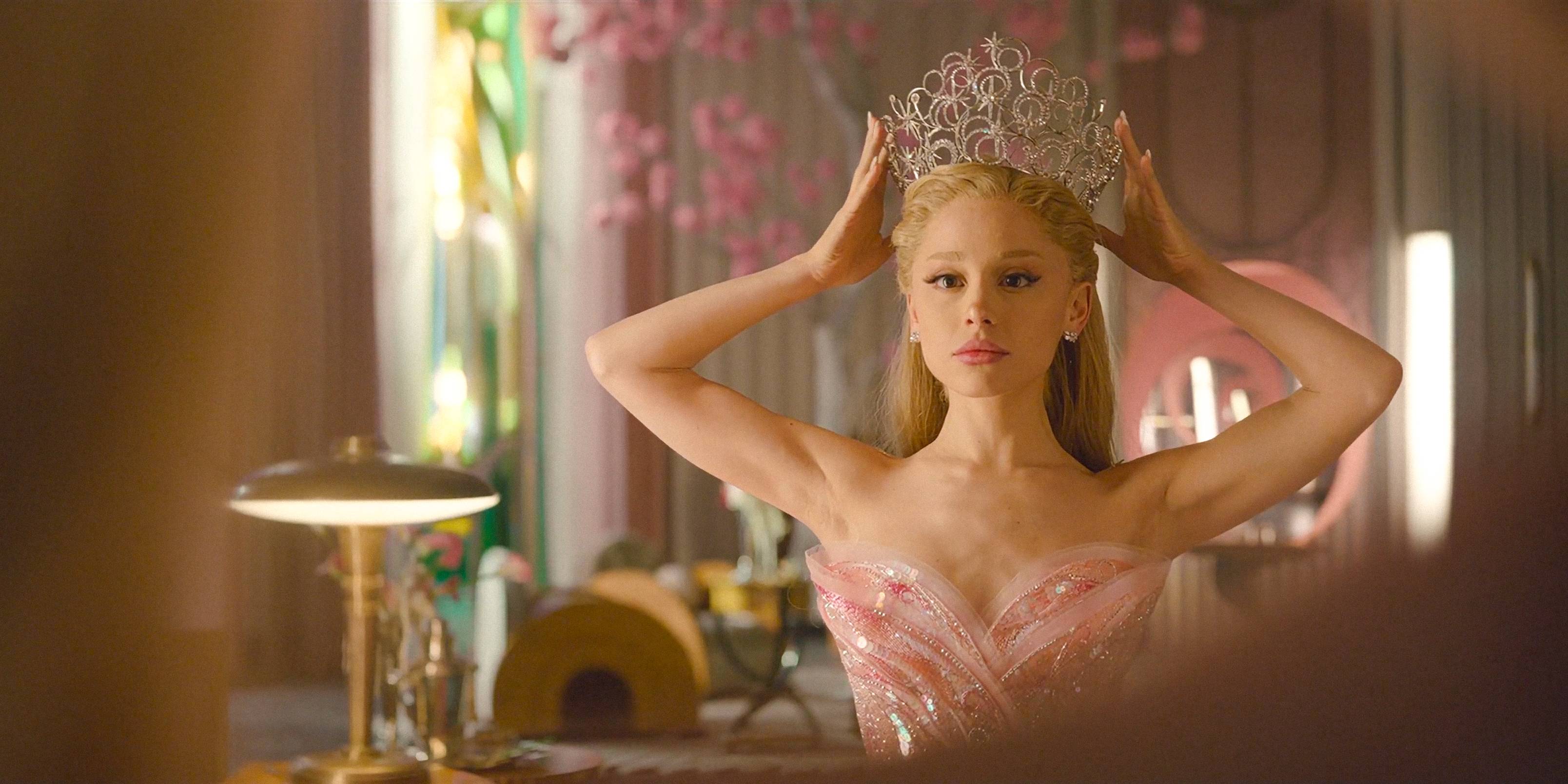 Glinda (Ariana Grande) carefully putting on her crown in her room in Wicked: For Good.