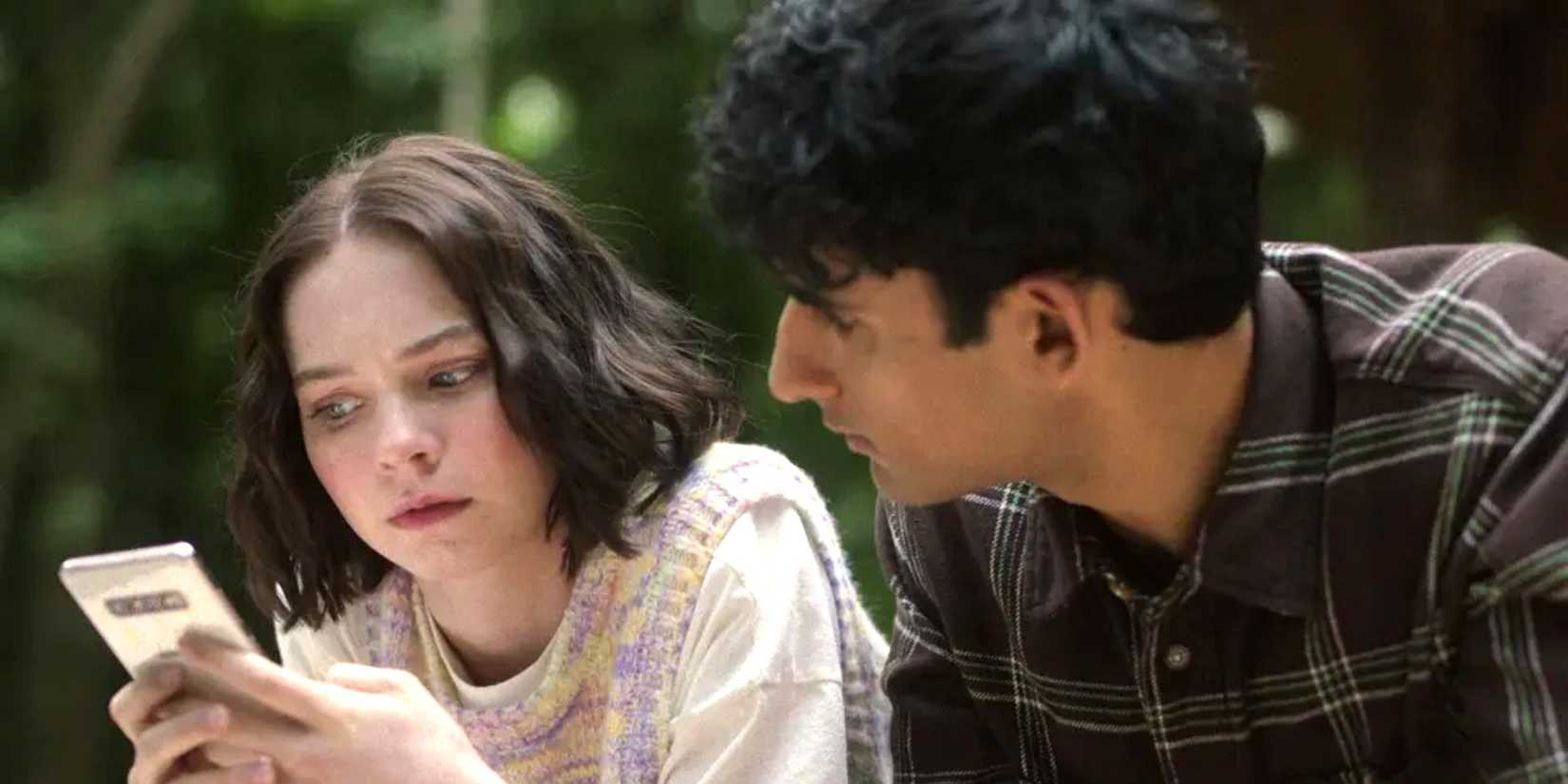 Pip (Emma Myers) and Ravi (Zain Iqbal) sitting together in A Good Girl's Guide to Murder