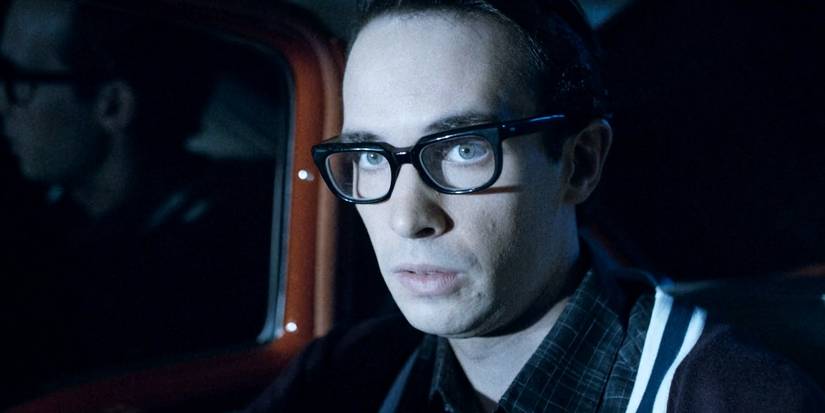 A man in glᴀsses staring in a car in The Vast Of Night