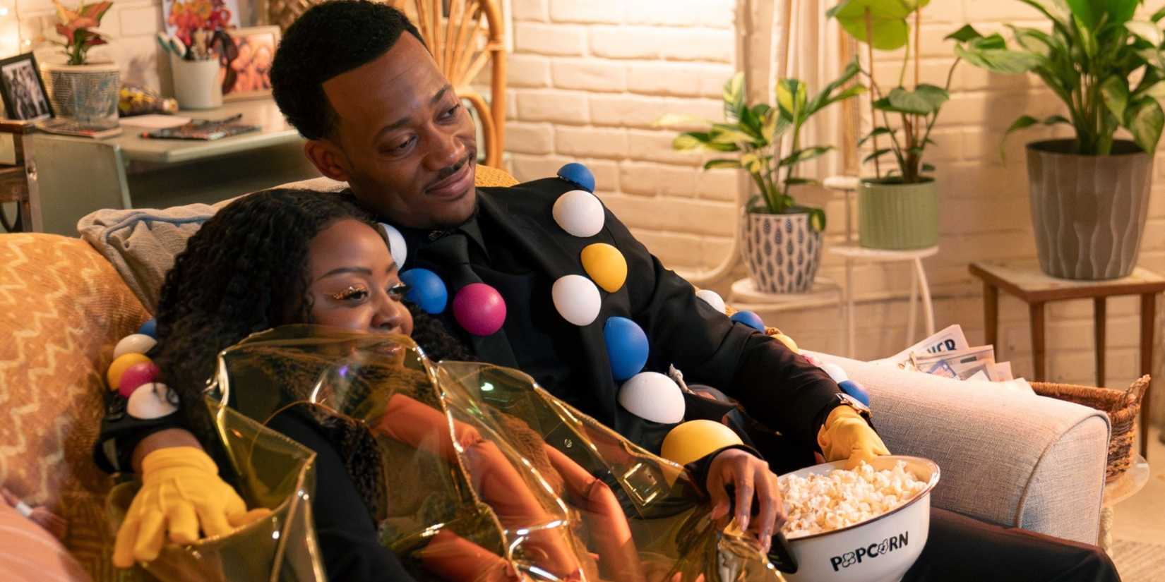 Janine and Gregory cuddling on the couch in their Halloween costumes in Abbott Elementary