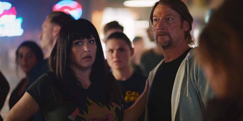 April Telek as Dolly and Aaron Pearl as Paulie looking preoccupied in Fire Country season 1, episode 11