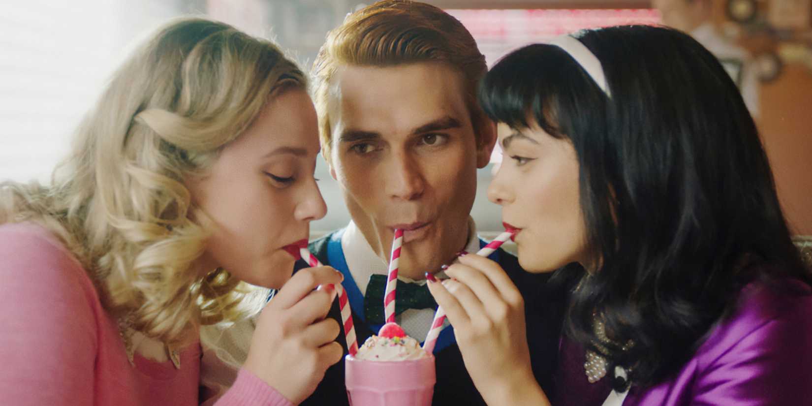Archie Betty and Veronica share a milkshake in Riverdale