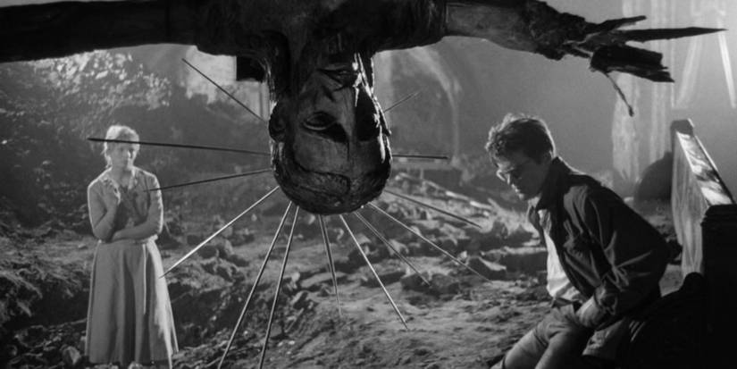 Two people talk in a bombed building with a statue of Jesus in the foreground in Ashes and Diamonds