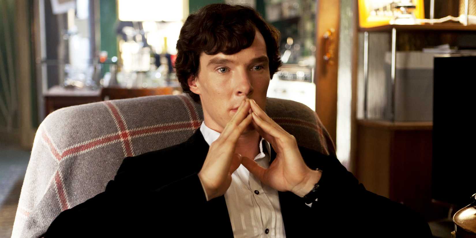 Benedict Cumberbatch pensativo como Sherlock Holmes na série da BBC