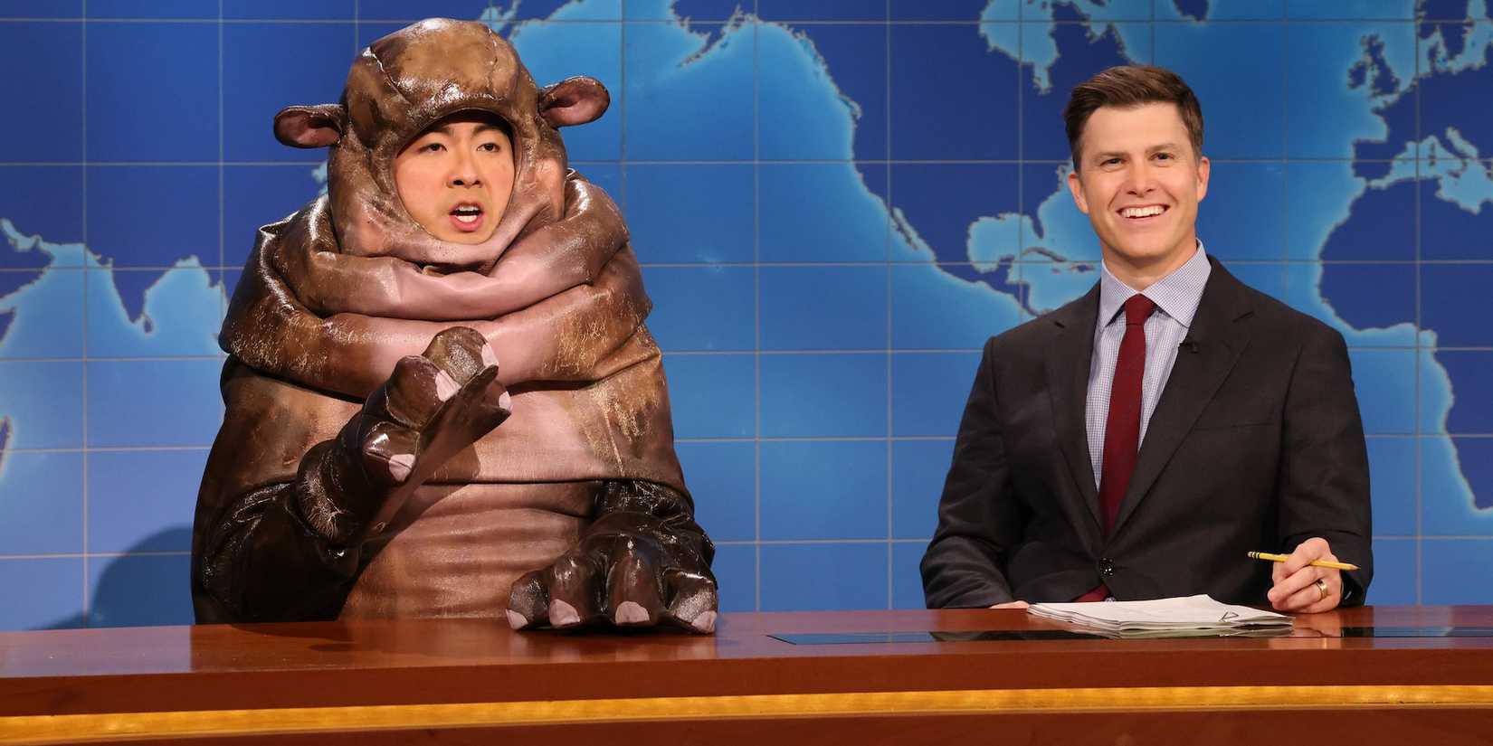Bowen Yang as Moo Deng next to Colin Jost during Weekend Update on Saturday Night Live