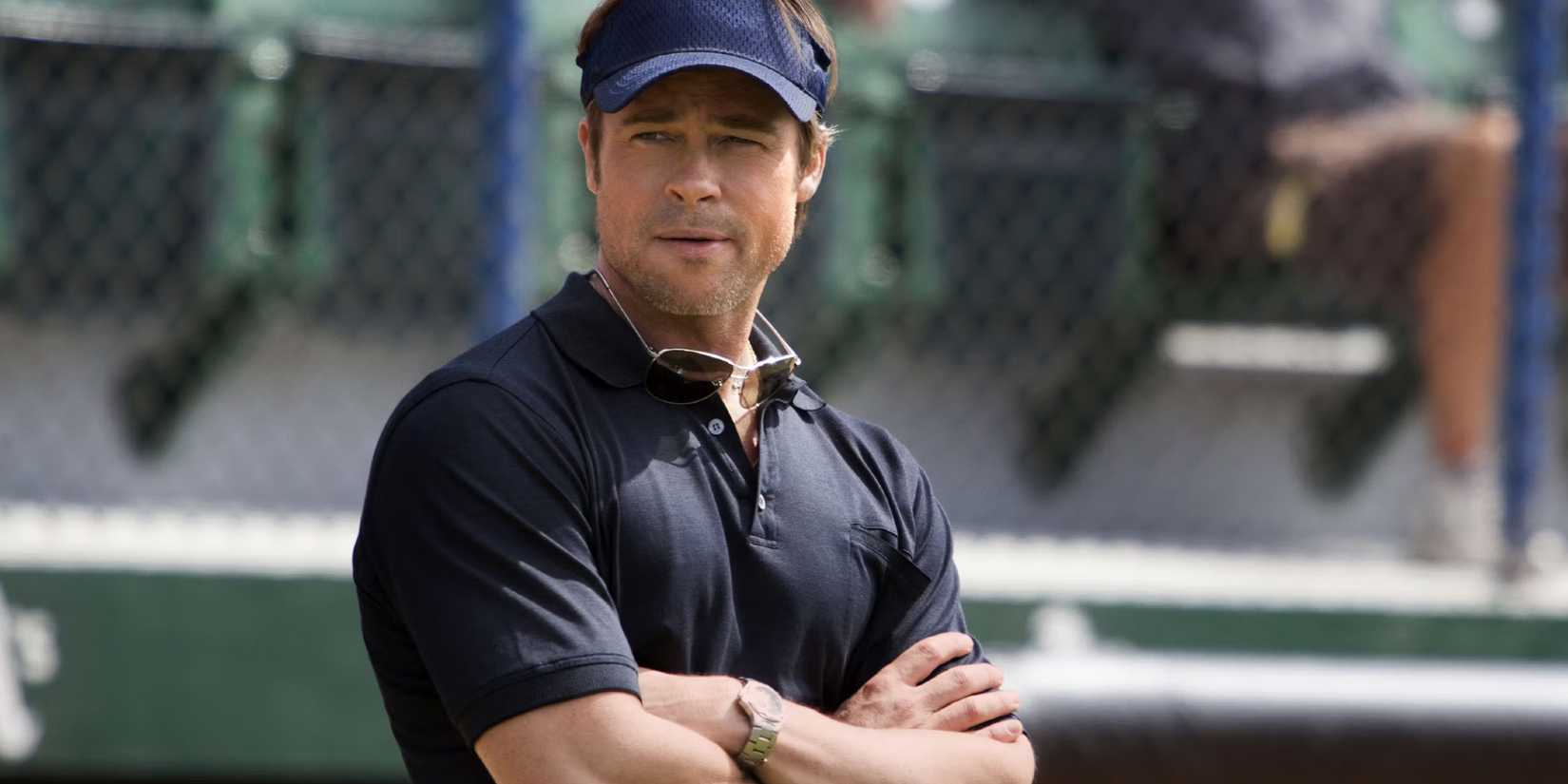 Brad Pitt crossing his arms on a baseball field in Moneyball