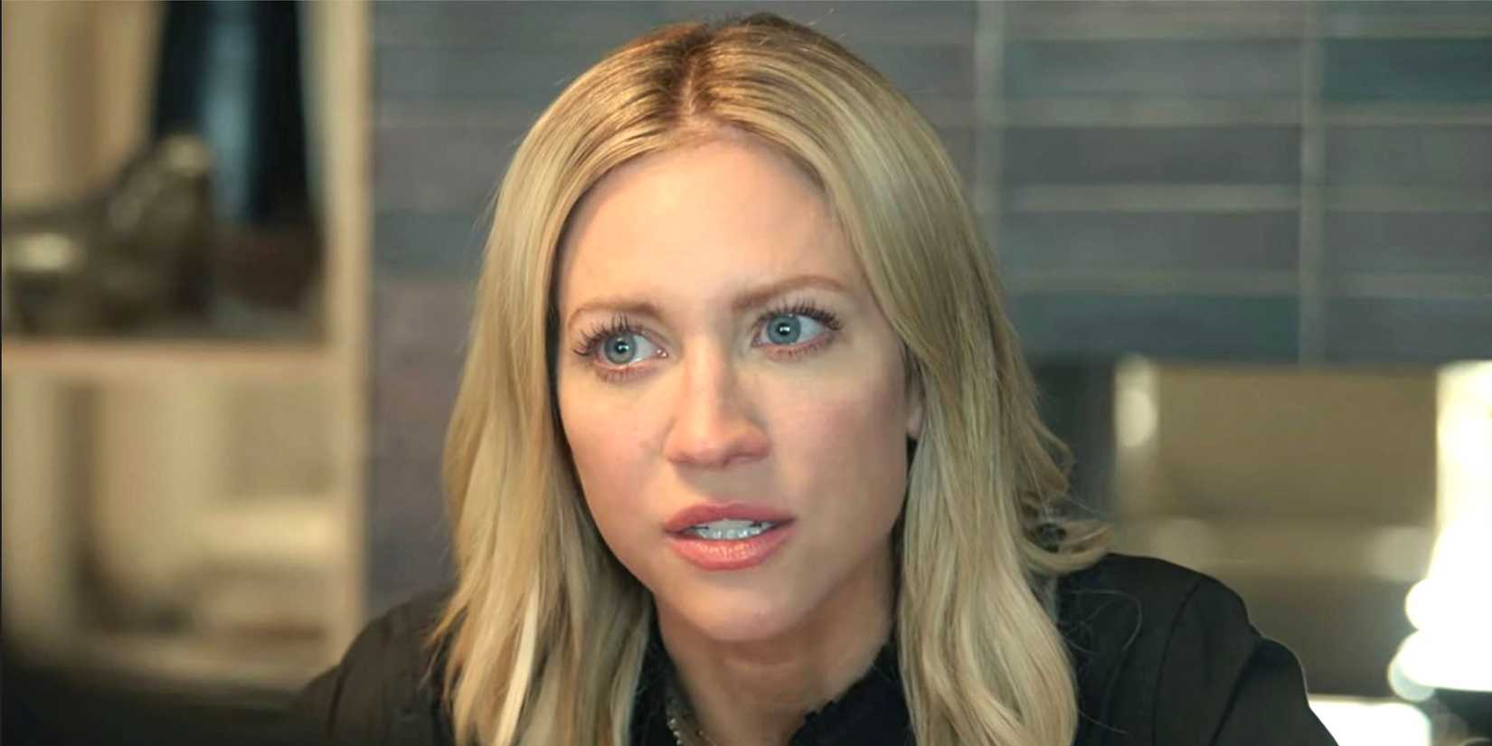 Brittany Snow's Sophie looks concerned sitting at a desk from The Hunting Wives