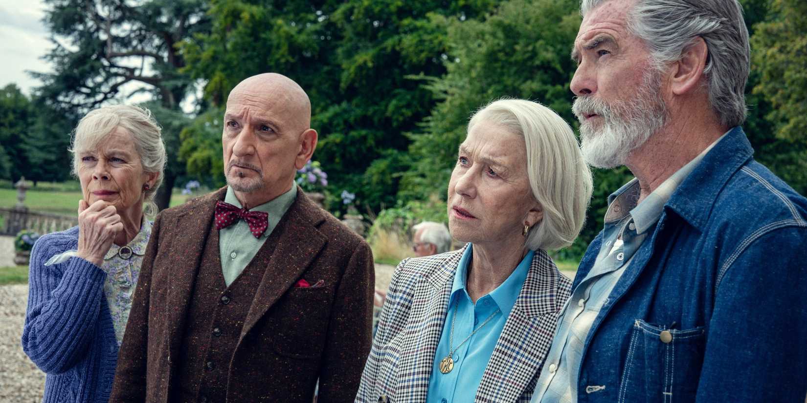 Celia Imrie, Ben Kingsley, Helen Mirren, and Pierce Brosnan standing together outside looking at something intently in The Thursday Murder Club