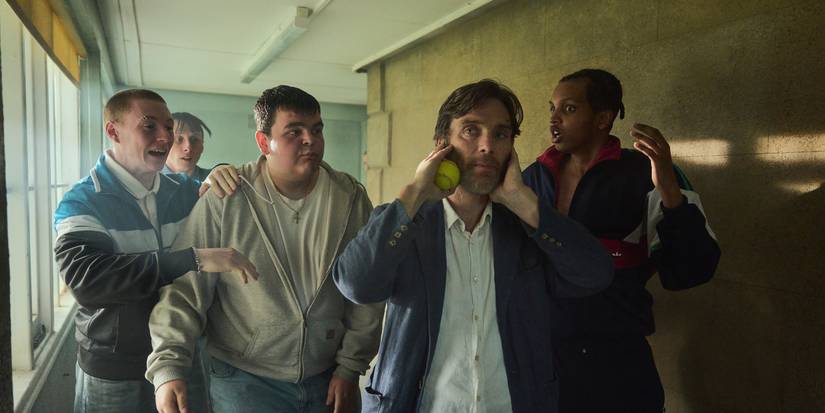 Cillian Murphy walking down a hallway with students in Steve