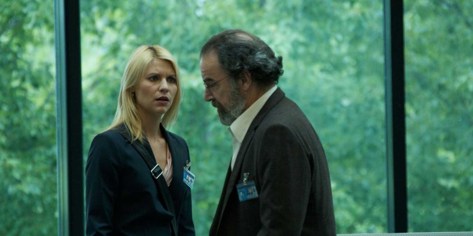 Claire Danes as Carrie Mathison looking shocked at Mandy Patinkin as Saul Berenson in front of a glass window in Homeland-1